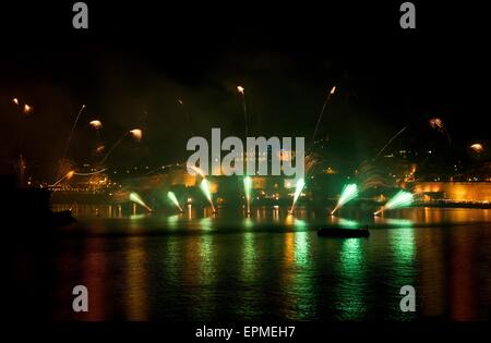 Fuochi d'artificio. Fuochi d'artificio colorati con sfondo di La Valletta, grande esplosione, casa di luce, riflessi verde su un'acqua di La Valletta Foto Stock