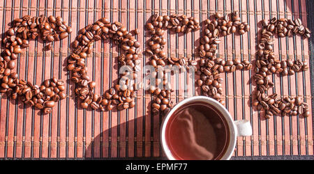 Coffe testo, chicchi di caffè e una tazza di caffè, su una tavoletta grafica Foto Stock