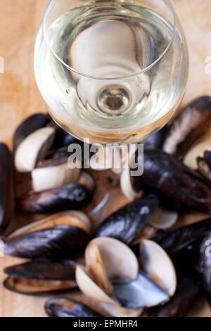 Un bicchiere di vino bianco con cozze e cardidi Foto Stock