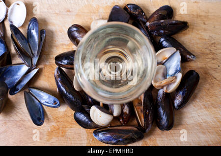 Un bicchiere di vino bianco con cozze e cardidi Foto Stock