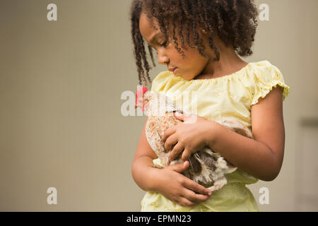 Una giovane ragazza con un pollo nelle sue braccia. Foto Stock