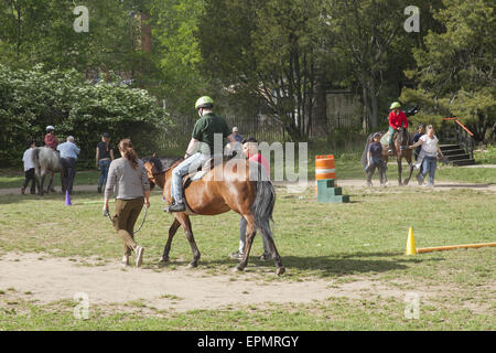 I bambini disabili ricevono terapia evolutiva imparare a cavalcare cavalli, noto come l'ippoterapia. Prospect Park di Brooklyn, NY Foto Stock