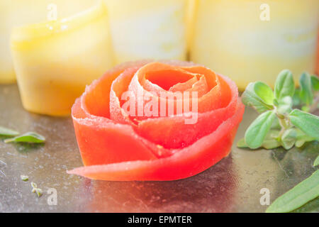 Un colorato fiore di pomodoro, nella parte anteriore del giallo le zucchine e le erbe aromatiche Foto Stock