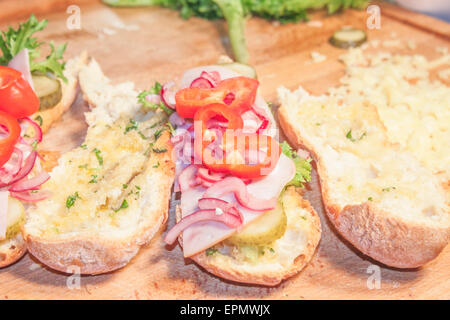 A pochi panini riempiti con pepe rosso, cipolla rossa e insalata mista Foto Stock