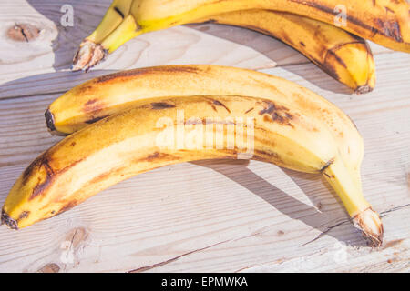 Un paio di vecchi giallo banane, su sfondo di legno Foto Stock