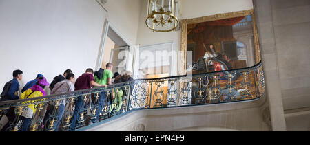 I turisti marciando su per le scale verso il XVII secolo la pittura del re Louis XIV presso il Château de Versailles Foto Stock