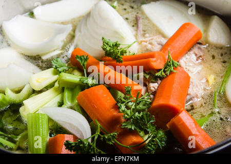 Una grande pentola su una stufa con verdure tagliate per rendere la zuppa Foto Stock