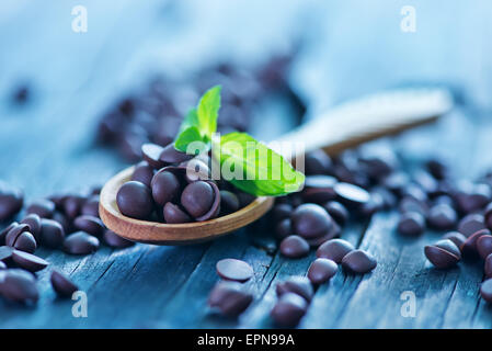 Dolci dolci al cioccolato in cucchiaio di legno e su di una tavola Foto Stock