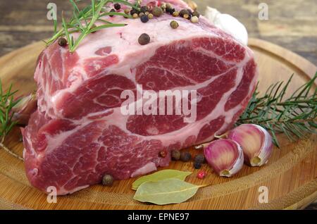 Collo con rosmarino e basilico sul tagliere Foto Stock