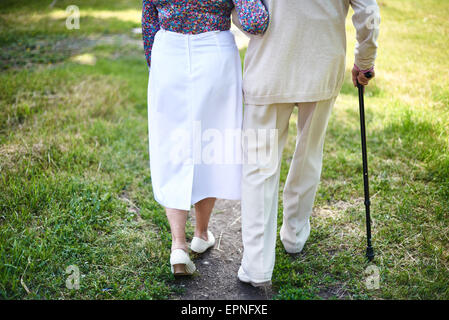 Vista posteriore di seniors passeggiate nel parco Foto Stock