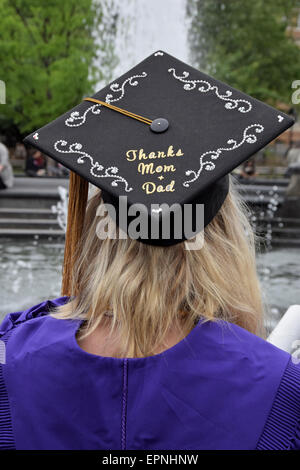 Una studentessa dopo NYU graduation esprimere grazie alla sua mamma e papà sul suo cappuccio. In Washington Square Park di New York City Foto Stock