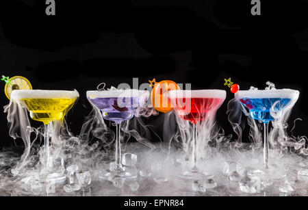 Martini bevande con ghiaccio secco effetto fumo, servito sul banco bar con sfondo nero Foto Stock