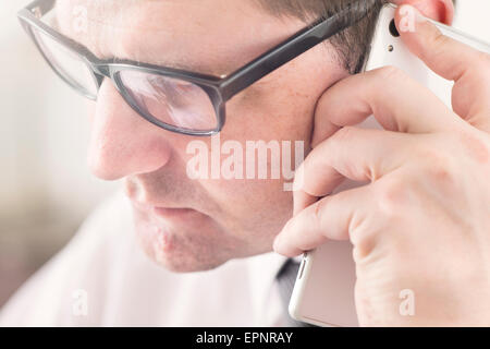 Imprenditore parlando al cellulare in ufficio. Foto Stock