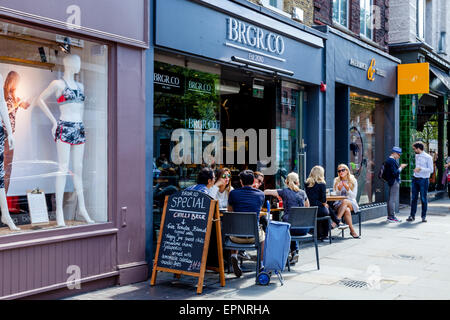 La gente seduta al di fuori di un cafè sulla King's Road, Londra, Inghilterra Foto Stock