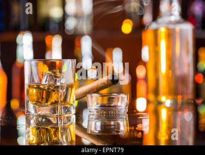 Whiskey drink con il fumo di sigaro sul bancone bar Foto Stock