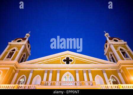 GRANADA, Nicaragua: La cattedrale di Granada, con il suo caratteristico esterno giallo e bianco, domina lo skyline del Parque Central. C'è una chiesa in questo luogo dal 1525 circa, ma è stata distrutta e ricostruita più volte nei secoli successivi, mentre la città di Granada è stata attaccata dai pirati e da altri. La costruzione della versione attuale è iniziata nel 1888, ma non è stata completata completamente fino al 1972. Con il suo distintivo colore giallo con rivestimento esterno bianco, si erge sul Parque Central nel cuore di Granada, Nicaragua. Foto Stock