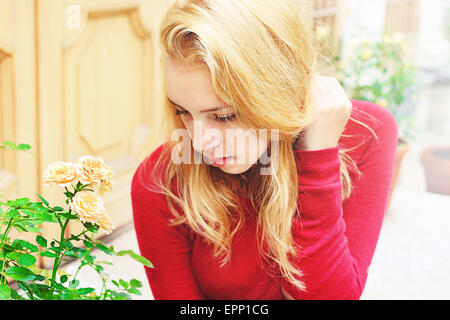 Ragazza giovane con lunghi capelli biondi, che ella tiene con la mano Foto Stock