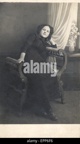 Retrò ritratto di una giovane ragazza in una sedia di vimini, circa 1915 Foto Stock
