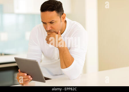 Riflessivo uomo di mezza età con tablet pc a casa Foto Stock