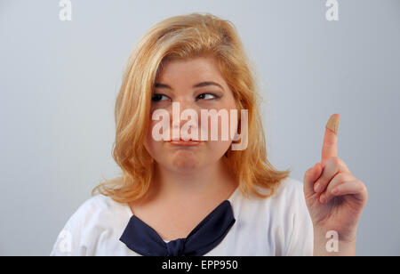 Una bella ragazza ha un taglio sul suo dito Foto Stock