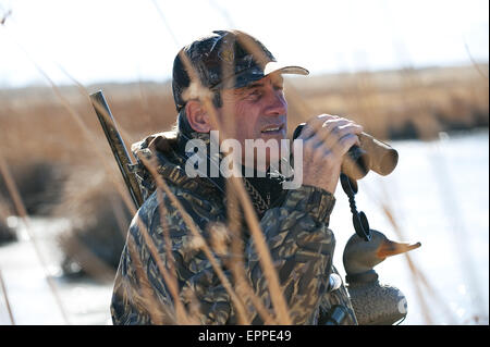 Un cacciatore utilizza un binocolo in Nevada. Foto Stock