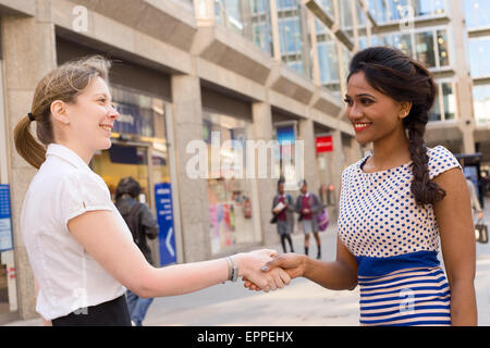 Due business ladies stringono le mani Foto Stock