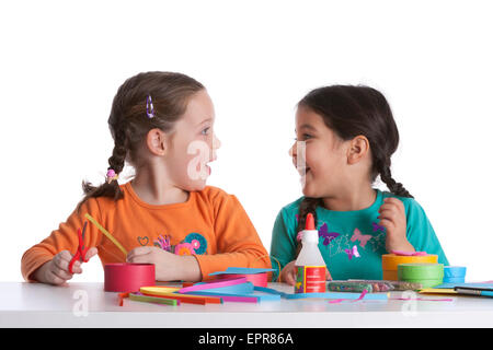 Due cinque anno ragazza amici facendo scherzi mentre facendo insieme artigianale Foto Stock