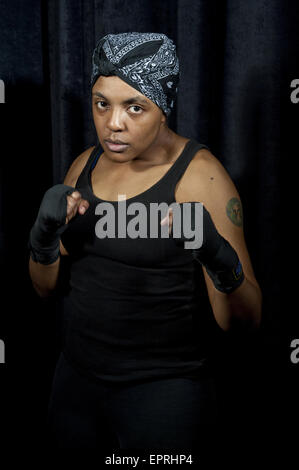 Una femmina di boxer che indossa la fascia che tiene le mani in alto in una posizione difensiva in un ritratto al Canadian Amateur Boxing Championships di Saint-Hyacinthe, Quebec. Foto Stock