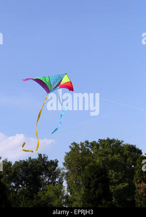 Colorato aquilone vola in alto nel cielo blu Foto Stock