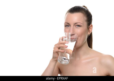 Sorridente bella donna sana di bere un bicchiere di acqua mentre guardando la telecamera, isolato su bianco Foto Stock