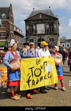 Popolo olandese in abbigliamento tradizionale di tenere un Tour de France bandiera presso il mercato del formaggio a Gouda, Paesi Bassi. Il 2015 Tour de France la volontà di avviare nei Paesi Bassi con la Grand partono da Utrecht. Credito: Stuart Forster/Alamy Live News Foto Stock