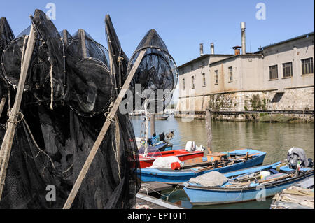 Le reti da pesca in banchina, in background le barche da pesca Foto Stock