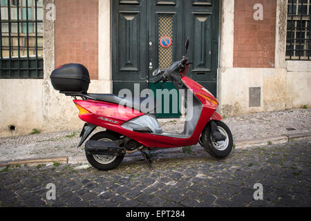 Honda porterà scooter parcheggiato in una strada di ciottoli di Lisbona Foto Stock