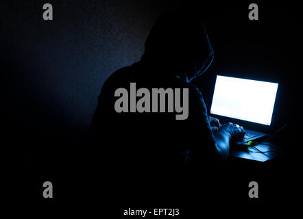 Singolo computer solitario hacker che lavora nel buio commettere un reato Foto Stock