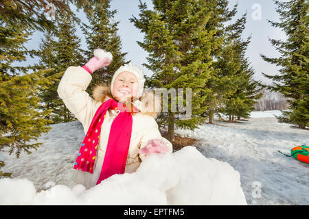 Ragazza ridere pronto a lanciare palle di neve nella foresta Foto Stock