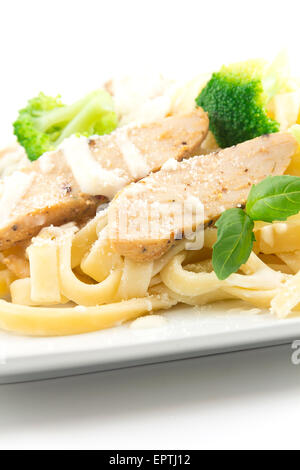 Chicken Fettuccini alfredo con foglie di basilico fresco e cotto a vapore broccoli freschi, deliziosa Foto Stock
