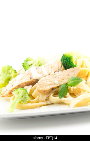 Chicken Fettuccini alfredo con foglie di basilico fresco e cotto a vapore broccoli freschi, deliziosa Foto Stock