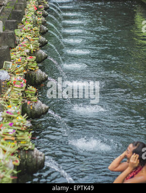 Bali, Indonesia - 21 maggio 2015: Gli Indù pregano durante la cerimonia di pulizia al Tempio di Tirta Empull. Gli stranieri sono benvenuti a partecipare alla cerimonia. Foto Stock