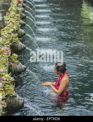 Bali, Indonesia - 21 maggio 2015: Gli Indù pregano e prendono parte ad una cerimonia di pulizia al Tempio di Tirta Empull Bali, Indonesia. Foto Stock