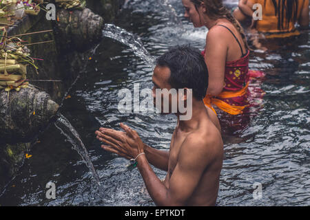 Bali, Indonesia - 21 maggio 2015: Gli Indù pregano durante la cerimonia di pulizia al Tempio di Tirta Empull. Gli stranieri sono benvenuti a partecipare alla cerimonia. Foto Stock