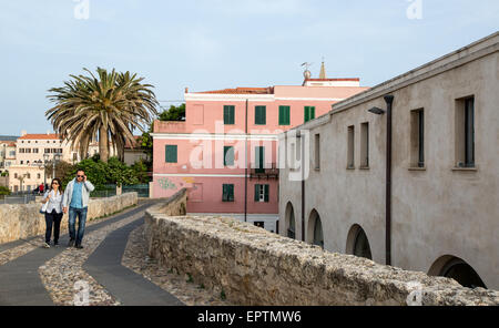 Giovane camminando lungo le mura della città di notte Alghero Sardegna Italia Foto Stock