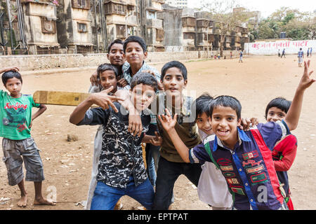 Mumbai India,Dharavi,Shahu Nagar Road,slum,sterrato lot,campo da cricket pitch,maschio ragazzo ragazzi bambini amici bambini,giocare,bat,segnali a mano,India150228035 Foto Stock