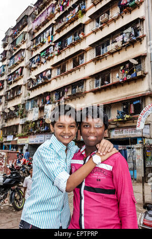 Mumbai India, Dharavi, 60 piedi strada, slum, poveri, basso reddito, poveri, povertà, ragazzi maschi ragazzi bambini amici bambini, alto aumento, edificio residenziale, lavanderia appeso Foto Stock