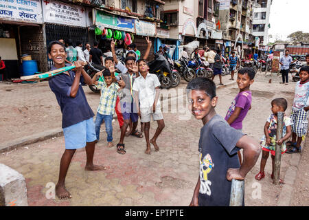 Mumbai India,Indian Asian,Dharavi,60 piedi strada,slum,basso reddito,povero,povertà,ragazzi ragazzi ragazzi ragazzi pazzi bambini bambini bambini, amici,giocare,cricket,pipistrello Foto Stock