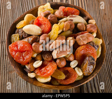 Un sano mix di dadi e frutta secca su sfondo di legno. Foto Stock