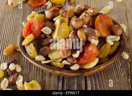 I dadi e la frutta secca su un sfondo di legno. Foto Stock