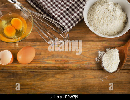 La cottura ingredienti uova, farina su uno sfondo di legno Foto Stock
