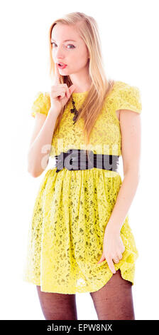 Giovane donna in piedi con il dito sulle labbra Foto Stock