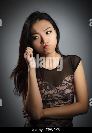Attraente ragazza asiatica nel suo ventenne isolato su un sfondo plein girato in uno studio Foto Stock