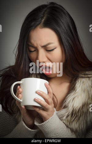 Attraente ragazza asiatica nel suo ventenne isolato su un sfondo plein girato in uno studio Foto Stock